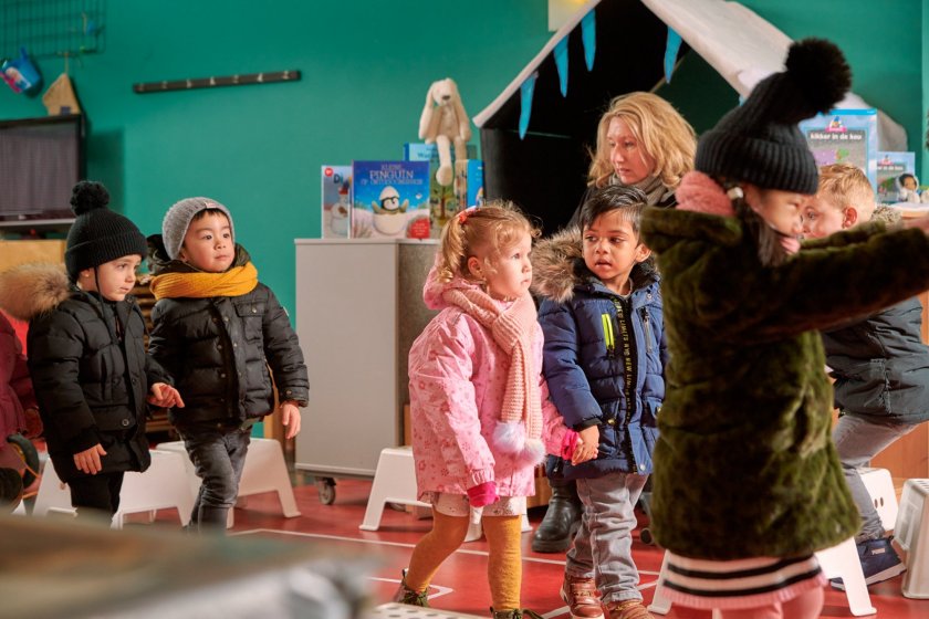 Peuters hebben een hun jas en lopen twee aan twee naar buiten.